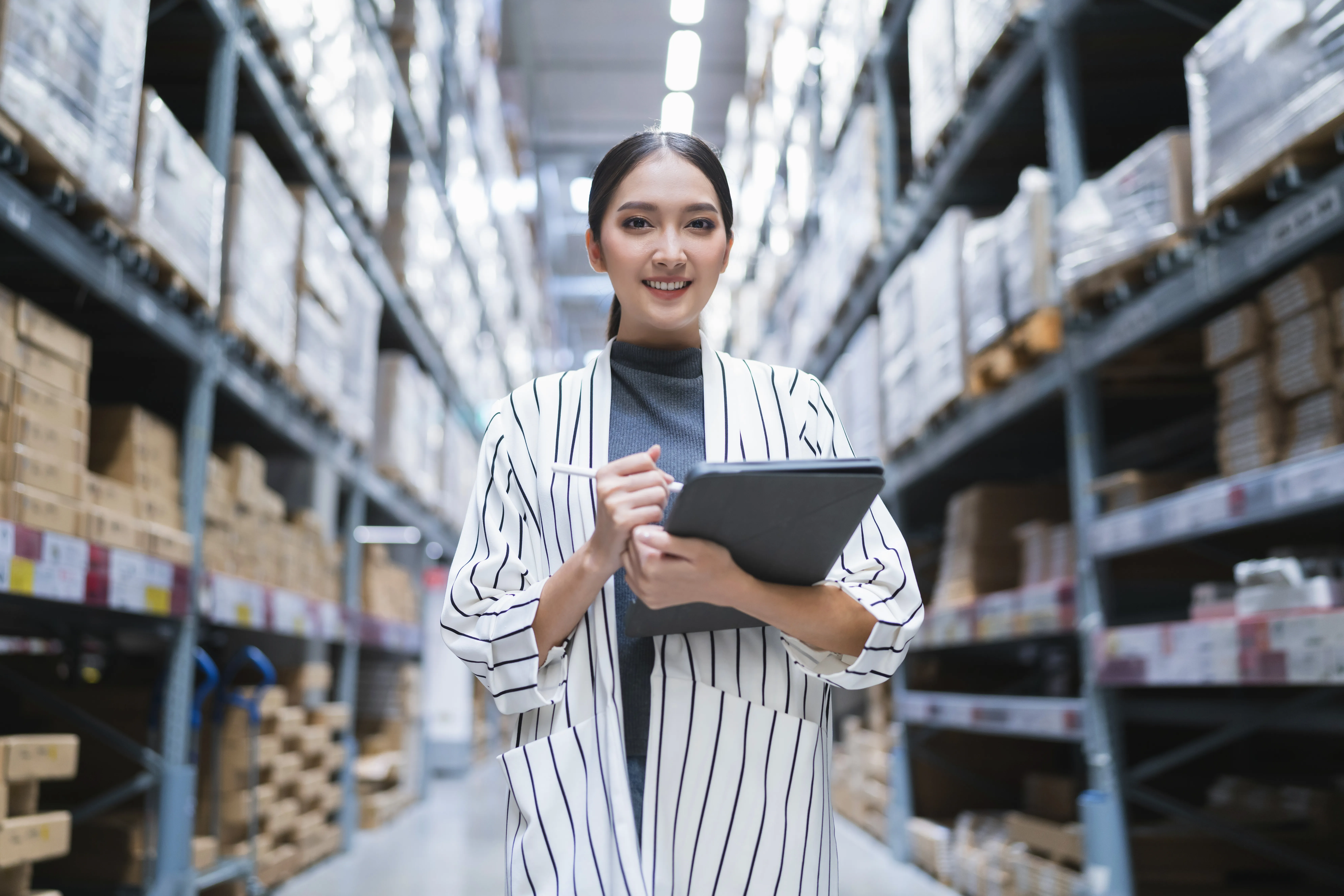 Portrait asian woman business owner using digital tablet checking amount stock product inventory she